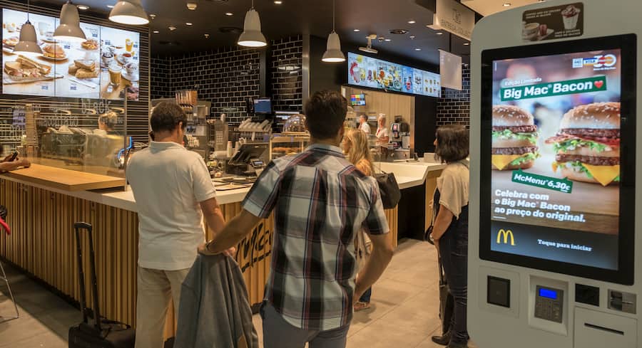 LISBON, PORTUGAL - SEPTEMBER 4: Travelers queue by McDonald's restaurant digital menu boards self-serve kiosks with touch screen in passenger area at Terminal 1 of Humberto Delgado International Airport on September 04, 2018 in Lisbon, Portugal. Portuguese tourist industry has gone through an excellent year in 2018, for the country is rated as very safe by travelers. (Photo by Horacio Villalobos - Corbis/Corbis via Getty Images)