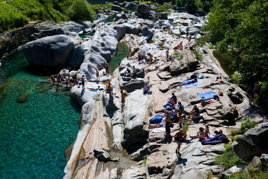 Menschen beim Sonnenbaden und Schwimmen in Wildbach Verzasca bei Lavertezzo