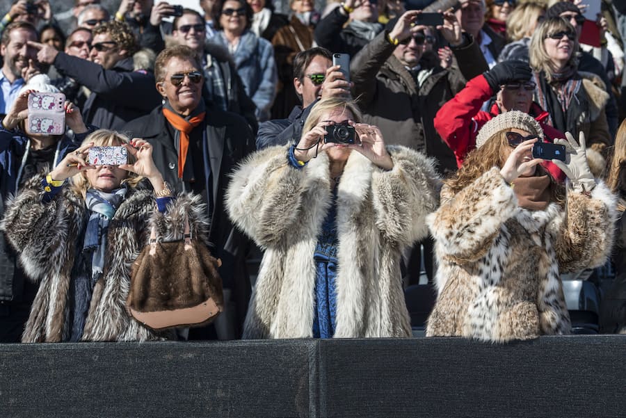 Visitors wearing fur coats take pictures, pictured at the White Turf in St. Moritz, Switzerland, on February 23, 2014. At the White Turf, among other horse races, there is also a skijoring race. (KEYSTONE/Christian Beutler)Zuschauerinnen im Pelzmantel sind am Fotografieren, aufgenommen am White Turf in St. Moritz am Sonntag 23. Februar 2014. Am White Turf findet unter anderem das Skijoering-Rennen statt. (KEYSTONE/Christian Beutler)